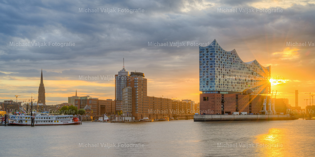 Elbphilharmonie in Hamburg Panorama  | Blick vom Musical Boulevard in Richtung Speicherstadt und Elbphilharmonie als für einen kurzen Moment die Sonne durch die Wolken bricht. - Realisiert mit Pictrs.com