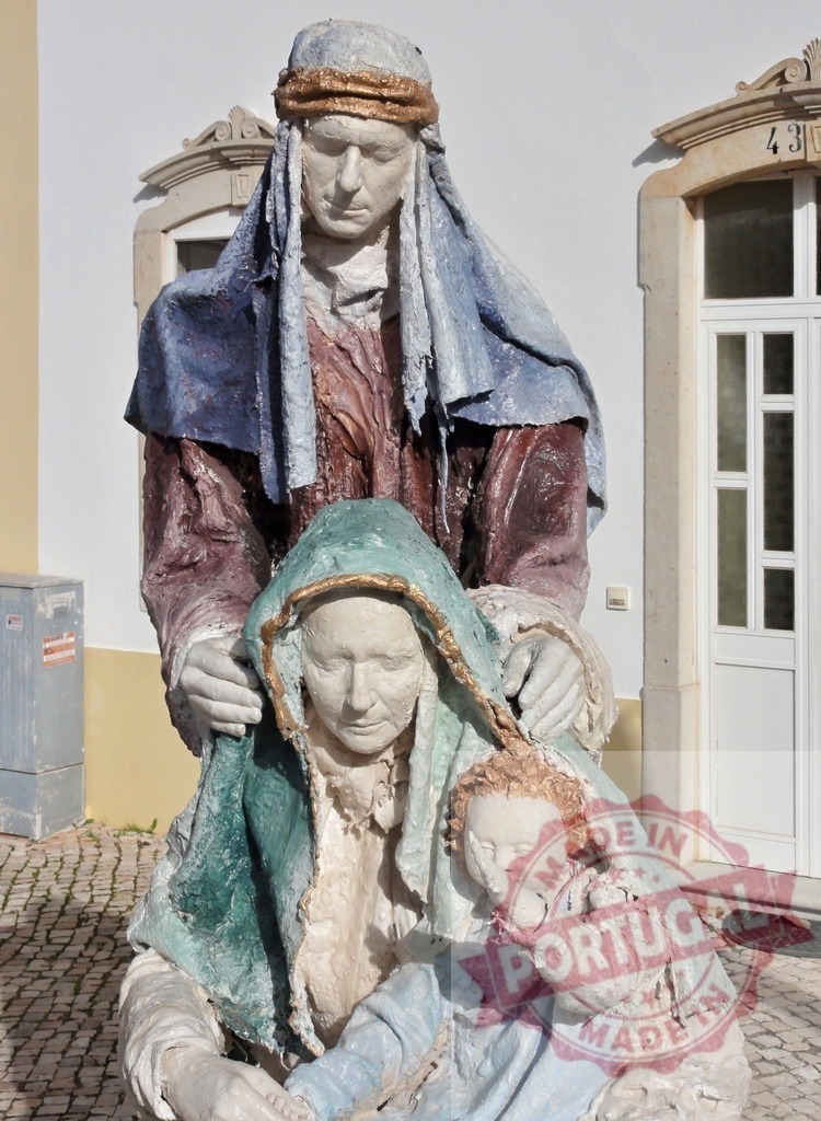 Painted plaster statue of the Holy Family in front of a house | Holy Family statue representing nativity scene with Joseph, Mary and baby Jesus - Realized with Pictrs.com