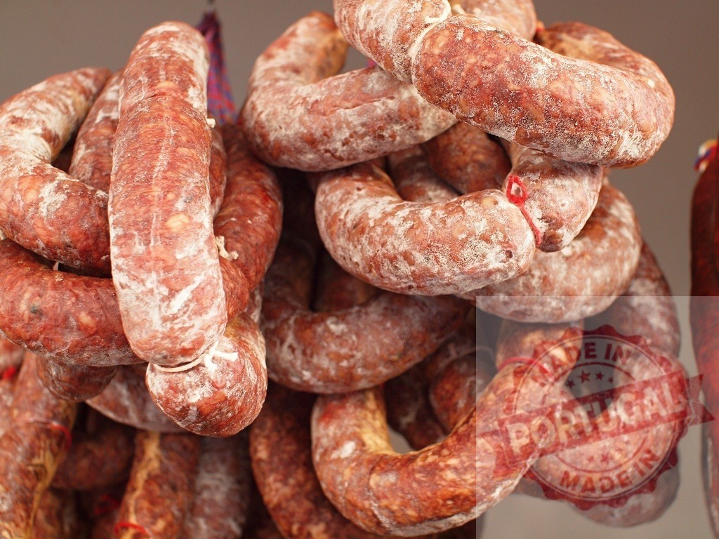 Artisan cured sausage hanging at market stall | Cured sausages are hanging in a traditional butcher shop or deli store - Realisiert mit Pictrs.com