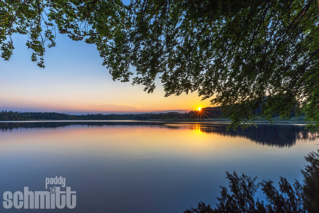 Abendstimmung am Holzmühle-Weiher bei Immenried | Abendstimmung am Holzmühle-Weiher bei Immenried. Das sanfte Licht der Abendsonne legt sich über den Weiher und die umliegende Landschaft. - Realisiert mit Pictrs.com