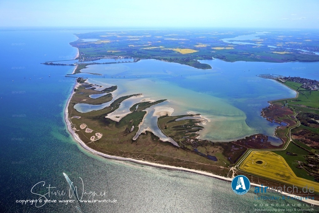 Luftbild Ostseefjord Schlei, Ostseeresort Olpenitz, Leuchtturm Schleimünde, Schleimündung, Lotsenhaus | Die Geschichte der Halbinsel reicht weit zurück: Schleimünde ist bereits in der altnordischen Jómsvíkinga saga als Slømynna und Slødyr sowie im Erdbuch Königs Waldemars von 1231 schriftlich dokumentiert. Im Jahr 1065 soll hier eine Seeschlacht zwischen dem Neffen des Königs Svens Estridsen, Asmund, und Hakon Iversen stattgefunden haben. Die Burg Oldenburg, südöstlich der heutigen Schleieinfahrt gelegen, stammt vermutlich aus dem frühen 12. Jahrhundert und war Teil eines Verteidigungssystems für den Handelsweg auf der Schlei.