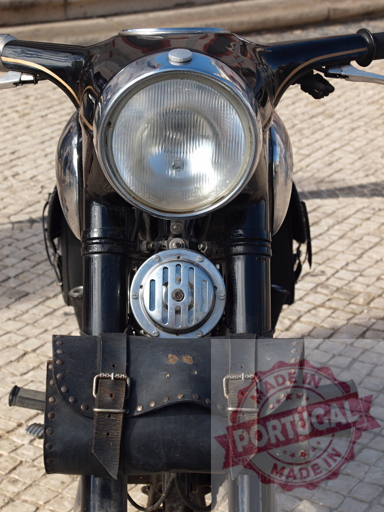 Vintage motorcycle headlight with classic leather bag | Close up view of a retro motorcycle headlight, horn, and leather tool bag - Realized with Pictrs.com