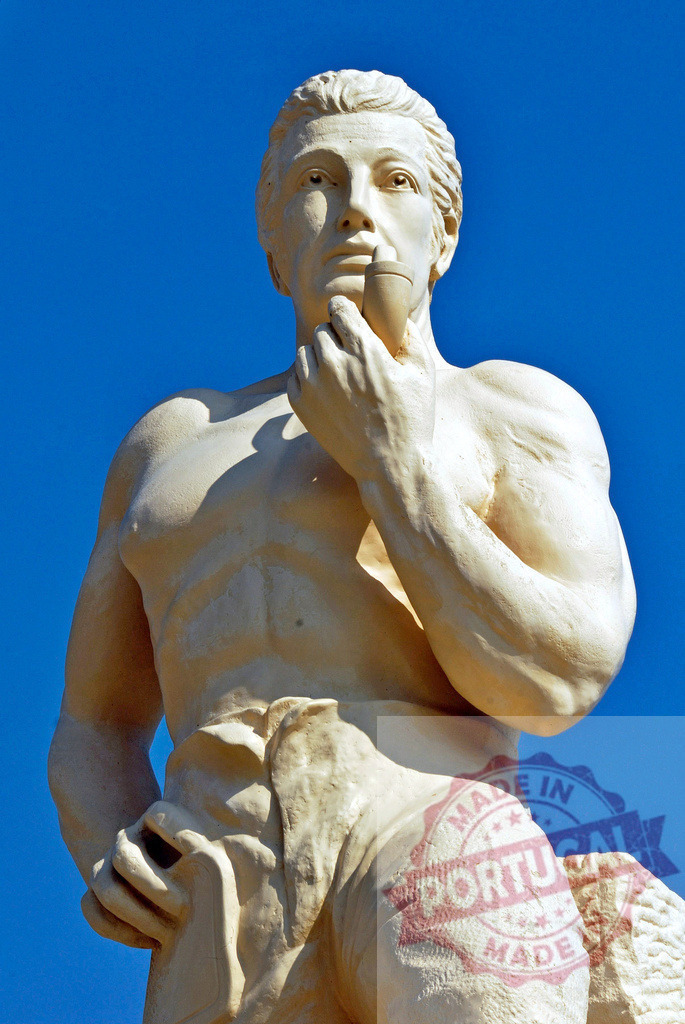 Muscular man statue thinking with pipe under blue sky | Stone statue of a muscular man holding a pipe, depicting thought and contemplation - Realisiert mit Pictrs.com