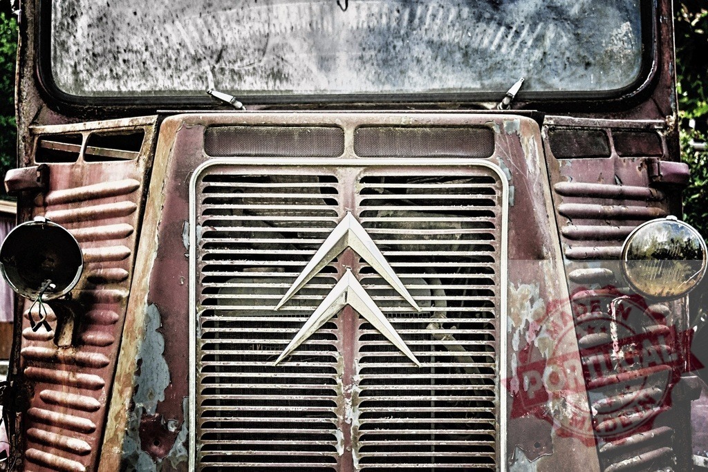 Old rusted Citroen H Van showing grille and emblem | Citroen H Van abandoned in a yard, showing rusted corrugated metal and emblem - Realized with Pictrs.com