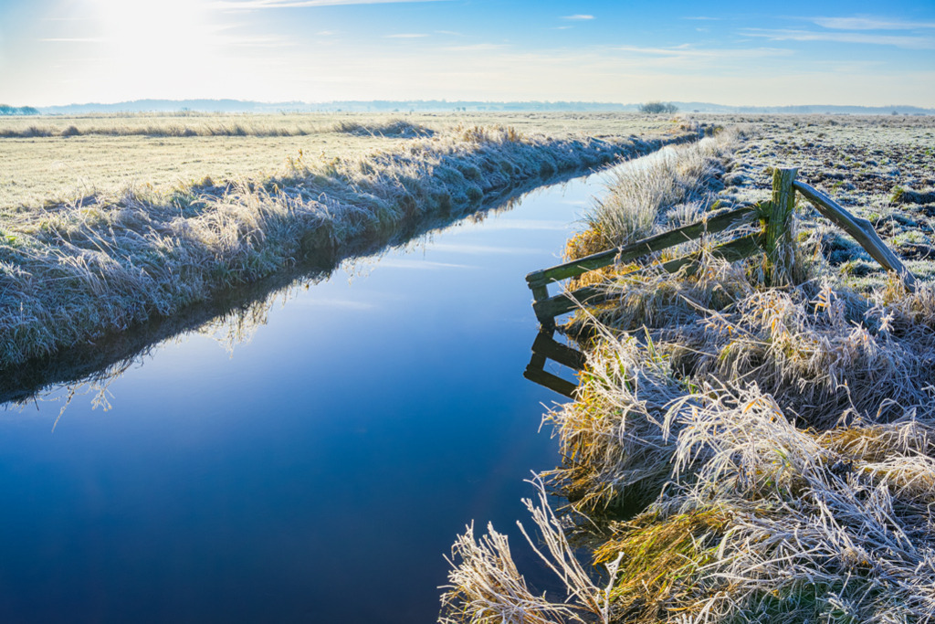 Graben im Winter | Der Noorsgraben liegt im Herzen des Kreises Dithmarschen, stetig und ruhig fließend, eingebunden in der beschaulichen Marschlandschaft. Über Feldwege mit dem Fahrrad dorthin zu fahren, ist im Winter ein Erlebnis für die Seele. — Auflösung des Originals: 6015 x 4010 px. - Realisiert mit Pictrs.com