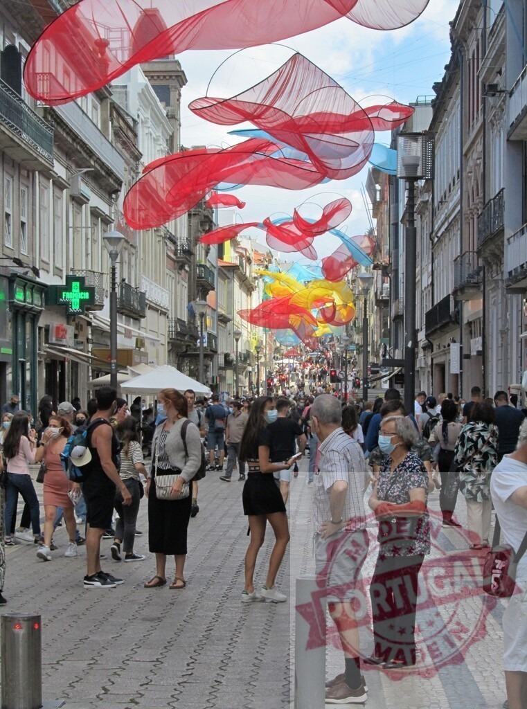 Porto Rua de Santa Catarina street with Echelman art installation. Porto - Portugal | Crowded pedestrian street featuring colorful Janet Echelman suspended artwork - Realized with Pictrs.com
