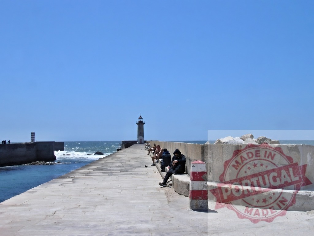 Lighthouse on breakwater leading into ocean. Norte - Portugal | People enjoying leisure time on a sunny pier with a lighthouse and blue ocean - Realized with Pictrs.com