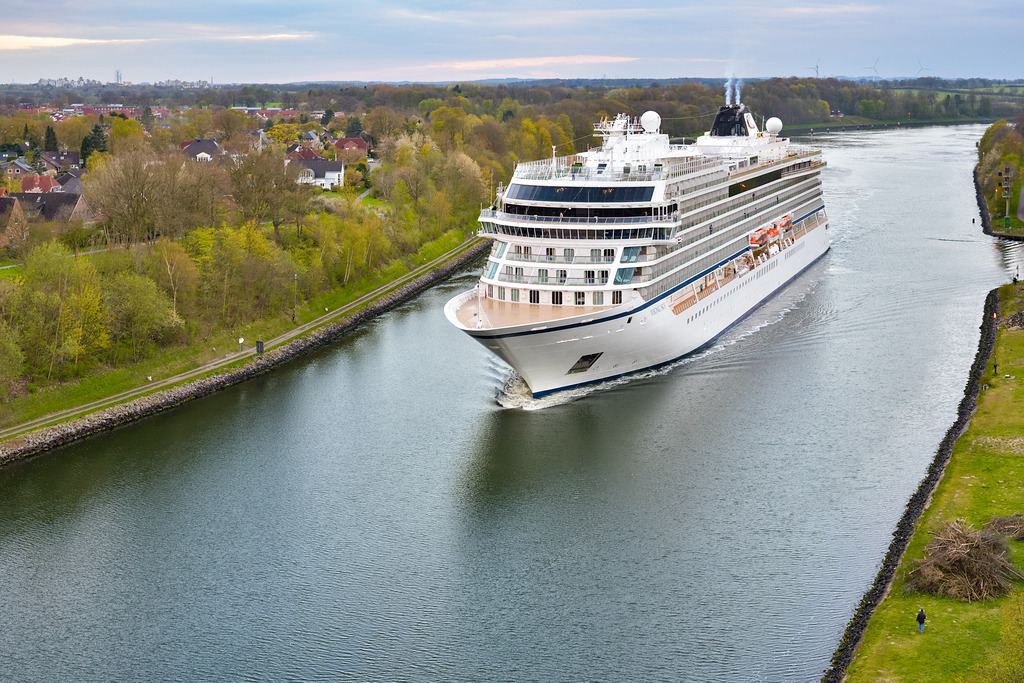 Viking Sky | Auf dem Nord-Ostsee-Kanal passiert das Kreuzfahrtschiff Viking Sky die Stadt Kiel. Das Schiff ist 228 Meter lang, es wurde im Jahr 2016 gebaut. - Realisiert mit Pictrs.com