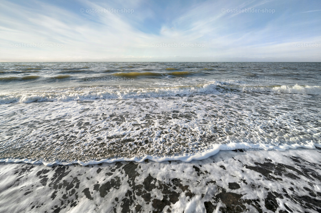 Wellenbild  | Schaumkronen nähern sich einem Steinestrand. Dabei entstehen kunstvolle Wellenmuster, die sich beim Vor- und Zurückfliessen des Wassers überlagern.