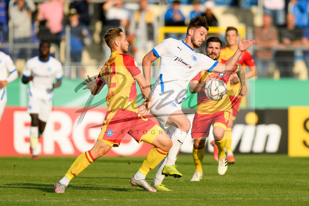 LOTKSC20210809_013 | Fussball, Herren: Christoph Kobald (Karlsruher SC) und Cedric Euschen (Sportfreunde Lotte) im Zweikampf beim Spiel der 1. Runde im DFB-Pokal zwischen SF Lotte und Karlsruher SC im Stadion am Lotter Kreuz am 09.08.2021 in Lotte, Deutschland.DFB / DFL REGULATIONS PROHIBIT ANY USE OF PHOTOGRAPHS AS IMAGE SEQUENCES AND/OR QUASI-VIDEO. - Realisiert mit Pictrs.com