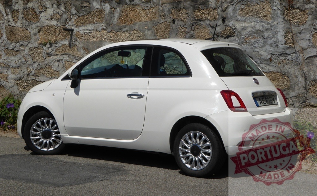 White Fiat 500 car parked by stone wall | White Fiat 500 car parked on an asphalt street next to an old stone wall - Realisiert mit Pictrs.com