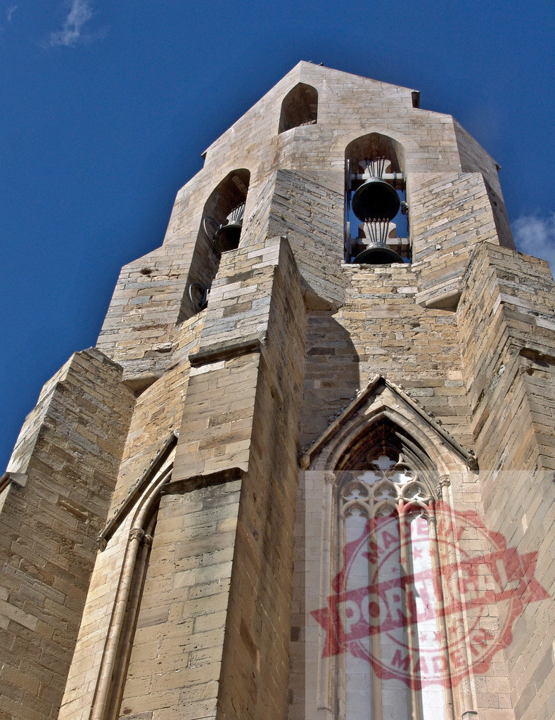 Girona Cathedral bell tower under blue sky. Provincia de Castellon | Girona Cathedral bell tower featuring Romanesque and Gothic architectural details against a clear blue sky - Realisiert mit Pictrs.com