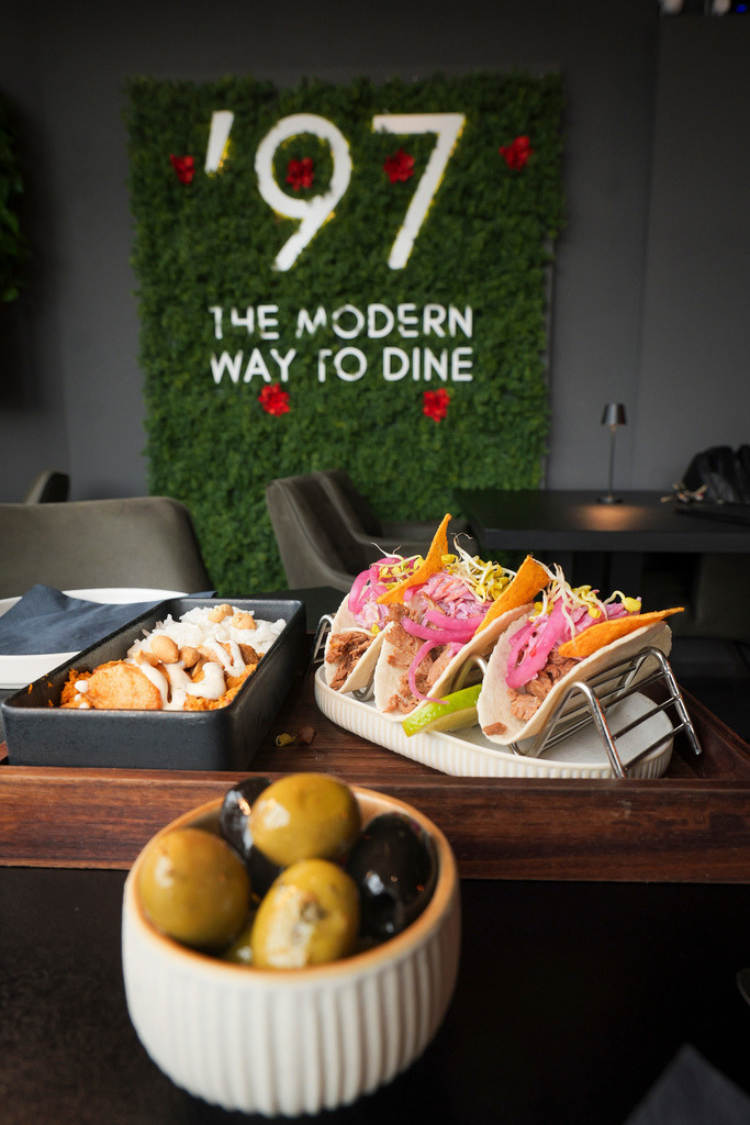 Taparia | Sindelfingen . Gastro - Taparia '97 in der Bahnhofstrasse. Im Bild:  Inhaber Daniel Kovacev mit Butter Chicken und 3 vegane Tacos mit Pulled Like Beef Tacos mit Coleslaw, nacho crunch, eingelegte Zwiebeln, und Sprossen - Realisiert mit Pictrs.com