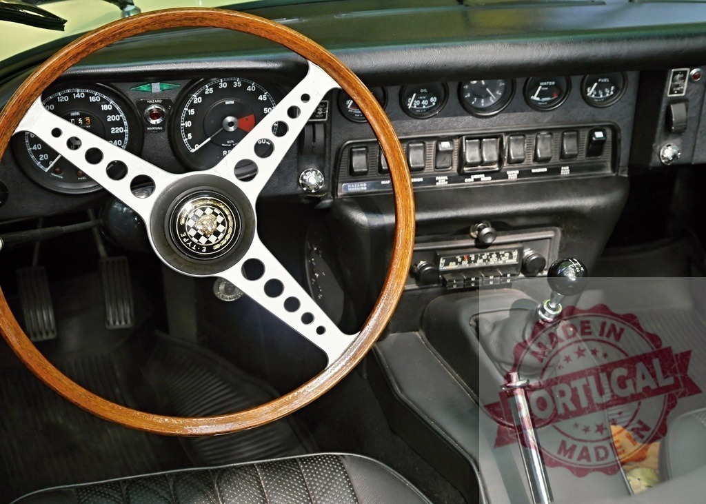 Jaguar E-Type classic car interior with steering wheel and dashboard | Jaguar E-Type vintage sportscar interior featuring a wooden steering wheel and manual gear stick - Realisiert mit Pictrs.com