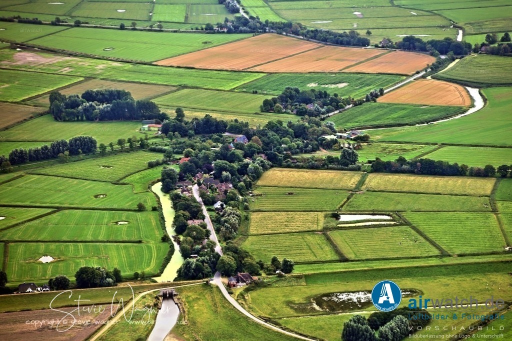 Luftbilder Everschopsiel Hafen | Sehenswürdigkeiten: 1.Lange Bank: Ein Kunstobjekt am Hafenbecken, das für Kommunikation und Attraktivitätssteigerung sorgt.2. Pier vor dem Schöpfwerk: Oft genutzt von Fischkuttern der Region.Steganlage: Für 6-10 Yachten, gut zugänglich und mit weichem Schlickgrund.3. Café Restaurant Spieskommer: Ein beliebtes Café in der Nähe des Hafens, das in der Sommerzeit geöffnet ist.