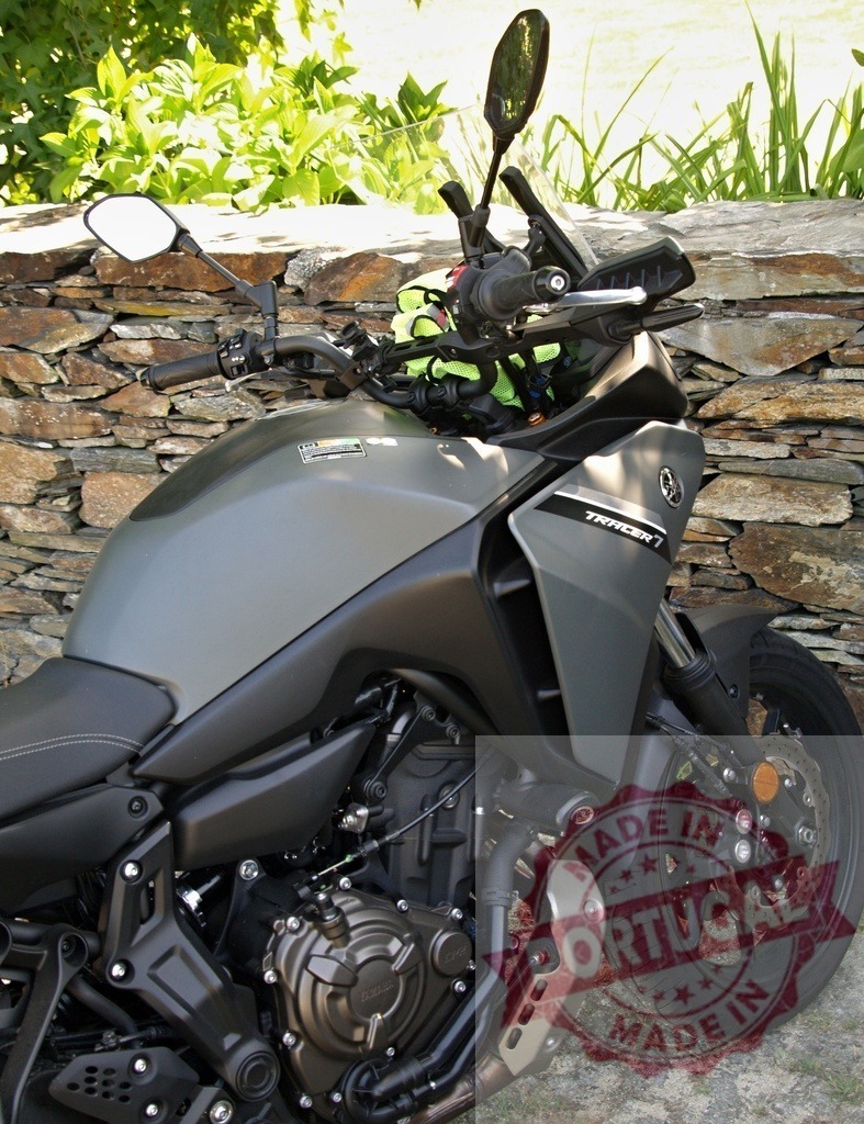 Yamaha Tracer 7 motorcycle parked near stone wall | Modern touring motorcycle Yamaha Tracer 7 parked near stone wall in sunny day - Realized with Pictrs.com