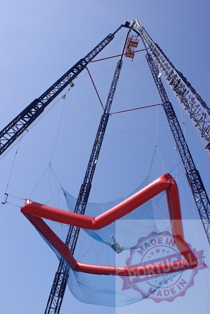 Extreme freefall amusement park ride net against sky | Man completing an extreme freefall drop into a large safety net at an amusement park - Realized with Pictrs.com