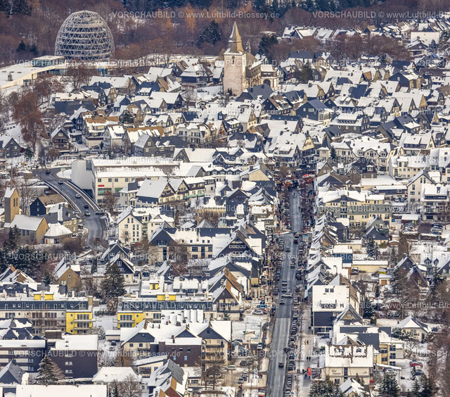 Winterberg221201379 | Luftbild Innenstadt, stark befahrene Straße Am Waltenberg, Kath. Kirche St. Jakobus der Ältere, Winterwunderland in Winterberg im Sauerland, am Kahlen Asten und den Skiabfahrten und dem Skilift-Karussell Winterberg, Winterberg, Sauerland, Nordrhein-Westfalen, Deutschland