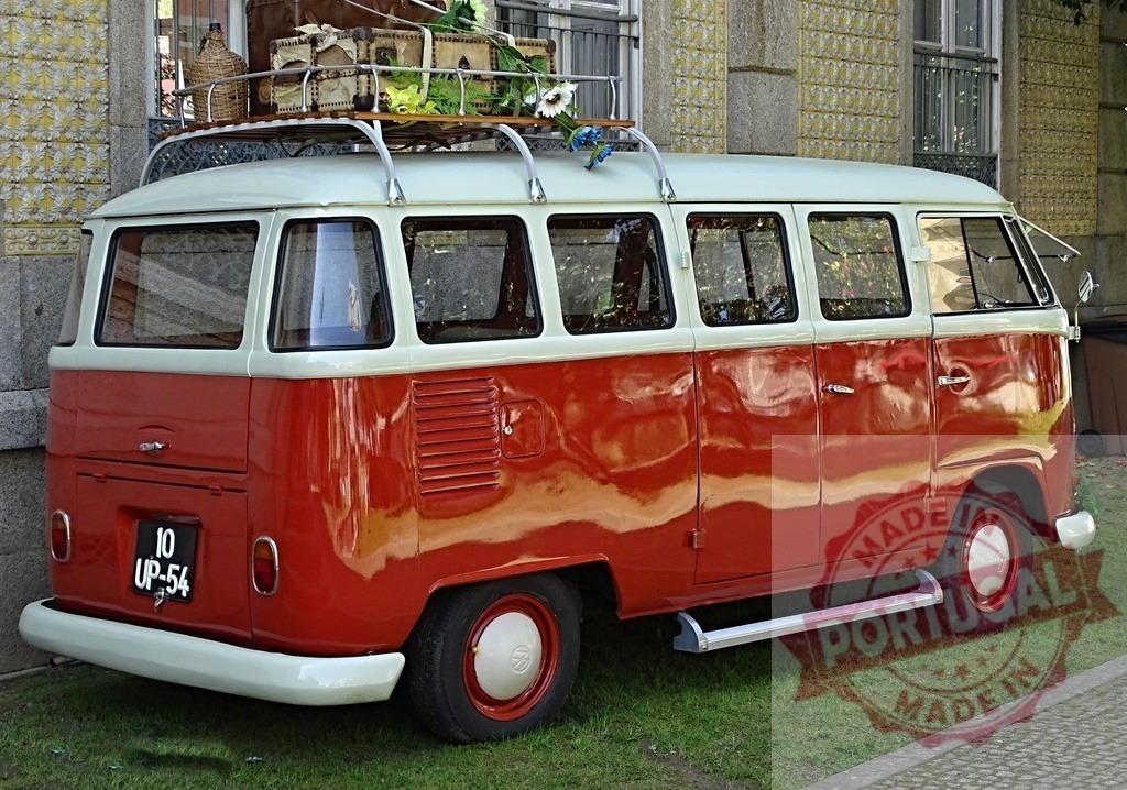 Volkswagen Type 2 vintage microbus parked with luggage rack | Volkswagen T2 camper van parked on green grass with antique suitcases and flowers on top - Realisiert mit Pictrs.com