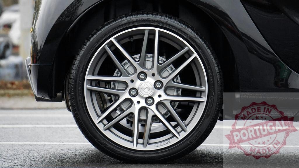 Brabus car wheel and tire on asphalt | Brabus luxury car wheel and tire featuring an alloy rim, brake system, and hubcap - Realisiert mit Pictrs.com