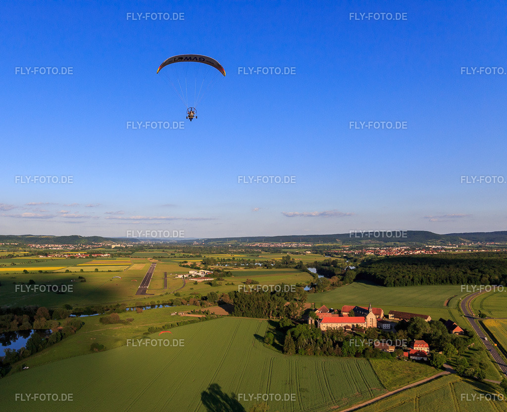Paragleiter über dem Gut Mariaburghausen mit Kirche St. Johannes der Täufer Mariaburghausen http://www.pfarreihassfurt.de/ | Luftbild: Paragleiter über dem Gut Mariaburghausen mit Kirche St. Johannes der Täufer Mariaburghausen http://www.pfarreihassfurt.de/ im Ortsteil Mariaburghausen in Haßfurt im Bundesland Bayern in Deutschland. Foto: IMG_100091.jpg vom 26.05.2017 durch Werner Riehm/FLY-FOTO.de - Realisiert mit Pictrs.com