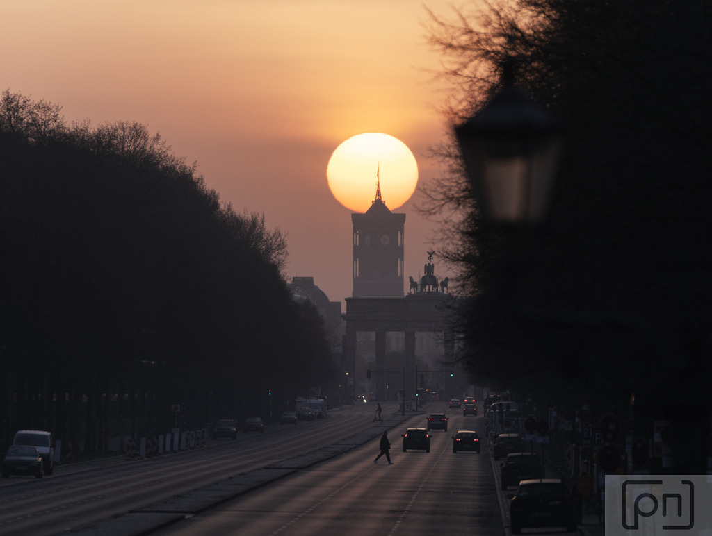  Saharasand in der Atmosphäre | Ein epischer Sonnenaufgang hinter dem Brandenburger Tor wird durch die Anwesenheit von Saharasand in der Atmosphäre zu einem faszinierenden Schauspiel. Die aufgehende Sonne taucht den Himmel in beeindruckende Farben, während der Saharasand ihm eine mystische Note verleiht. Das Licht bricht sich durch feine Sandpartikel und erzeugt ein atemberaubendes Spektakel von goldenen und rötlichen Tönen. Die Szene vereint die majestätische Architektur des Brandenburger Tor's und dem Roten Rathaus mit der künstlerischen Pracht der Natur, und der Anblick ist gleichzeitig surreal und erhaben