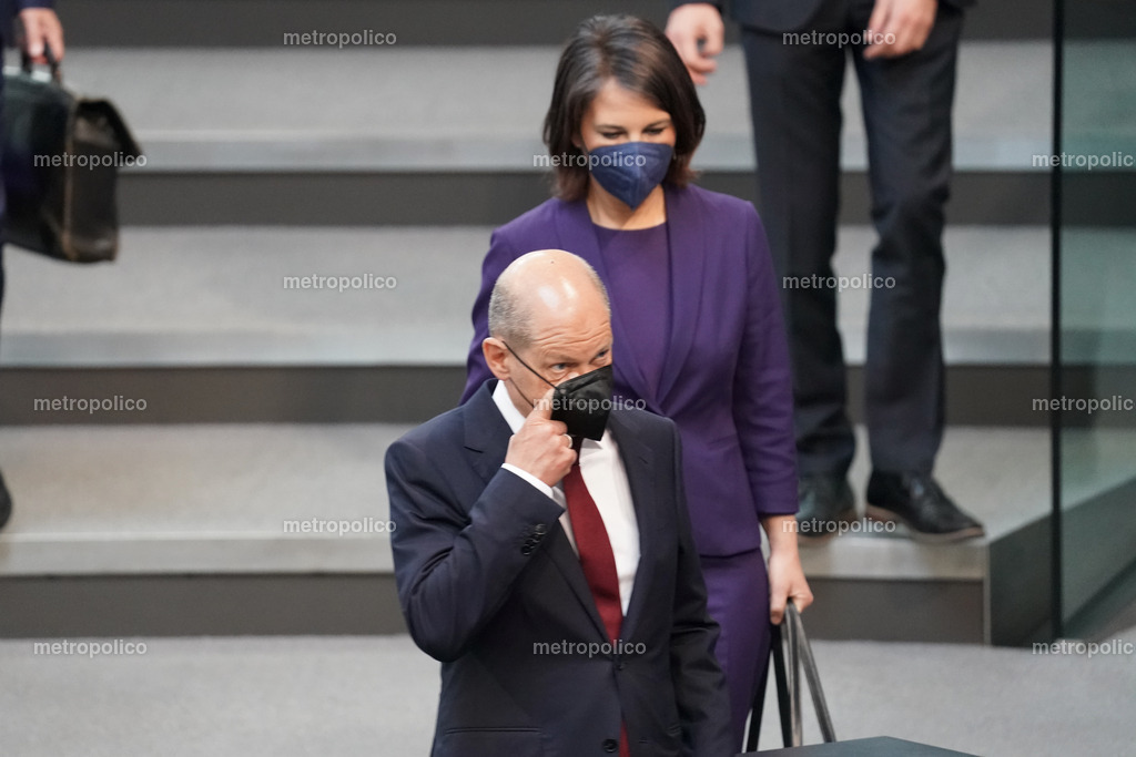 Olaf Scholz mit dem Finger unter der Maske Annalena Baerbock hinter ihm | Metropolico