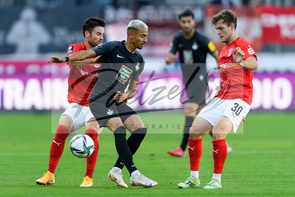 HFCFCK20210824_024 | Fussball, Herren: Niklas Kreuzer (Hallescher FC), Kenny Redondo (1. FC Kaiserslautern) und Tom Zimmerschied (Hallescher FC) im Zweikampf beim Spiel der 3. Liga zwischen Hallescher FC und 1. FC Kaiserslautern im Leuna-Chemie-Stadion am 24.08.2021 in Halle (Saale), Deutschland. - Realisiert mit Pictrs.com