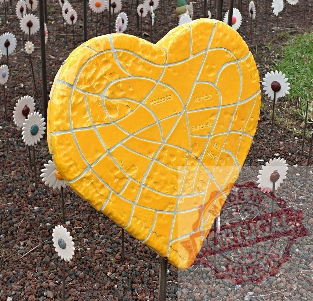 Yellow mosaic heart sculpture honoring Modesto Martinez Sanchez | Yellow ceramic heart sculpture with names displaying a memorial garden tribute - Realized with Pictrs.com