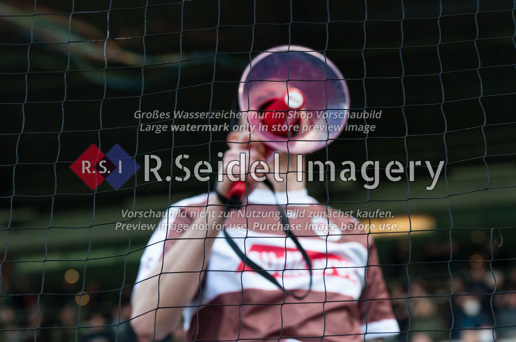 Fußball, Saison 2021/22, 2. Bundesliga, FC St. Pauli - SV Werder Bremen, Millerntorstadion (Hamburg), 09.04.2022, 29. Spieltag | FC. St. Pauli Fan mit Megafon vor dem Gesicht hinter dem Ballfangnetz in der Südkurve