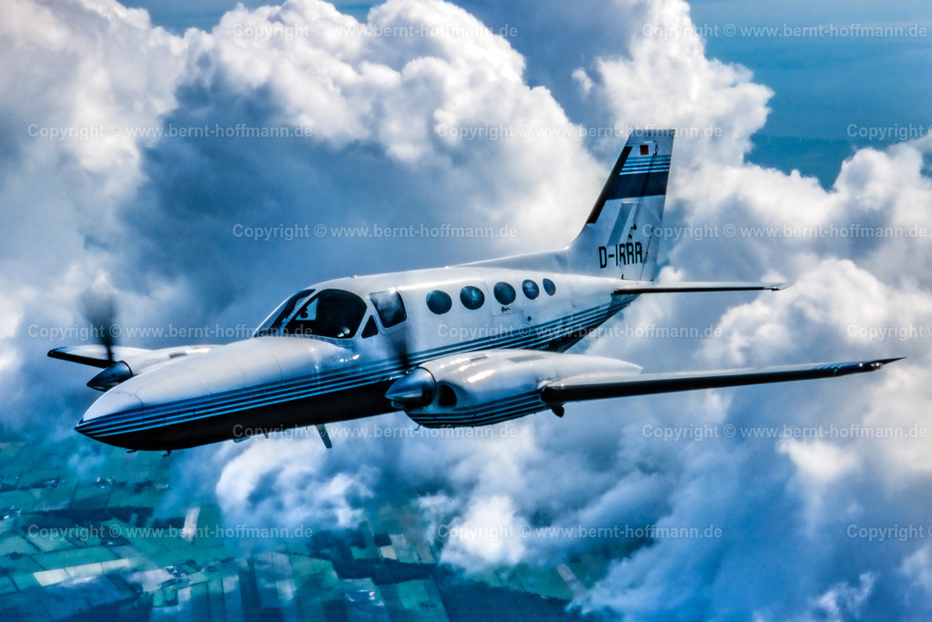 PLBDD_air2air_C421_105x70 | Luftbild. Zweimotoriges Geschäftsflugzeug ( Typ CESSNA 421 ) über den Wolken und zwischen Cumulus- Wolken im Luftraum zwischen Flensburg und Nordfriesland. ___ Das Foto ist eine Reproduktion von einem Farbdia. Bildanmutung = farbreduziert. - Realisiert mit Pictrs.com