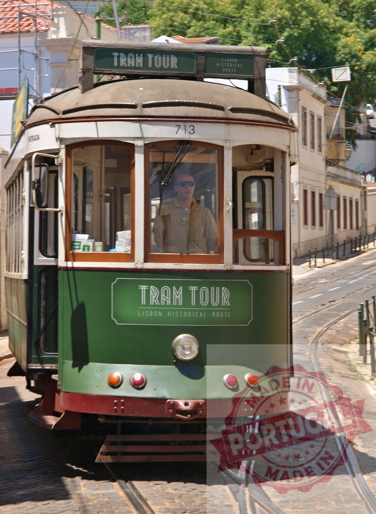 Green and white tram driving uphill in Lisbon | Vintage tram driving uphill in Lisbon on a sunny summer day - Realized with Pictrs.com