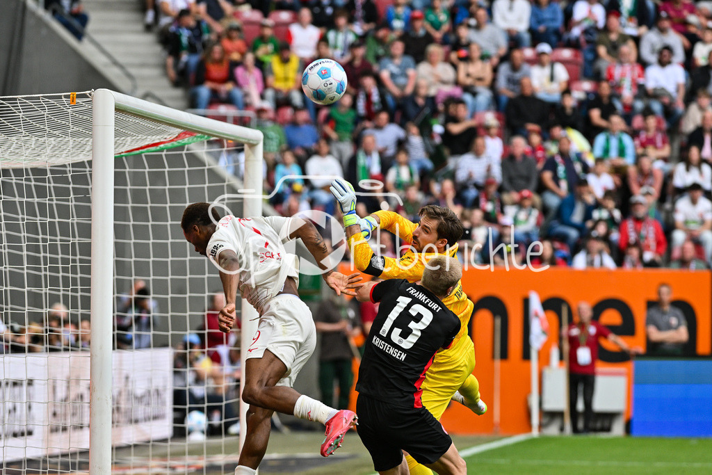 FC Augsburg - SG Eintracht Frankfurt | v. l. Samuel Emmanuel ESSENDE MBONGU (FC Augsburg 9), Kevin TRAPP (Eintracht Frankfurt 1) und Ramsmus KRISTENSEN (Eintracht Frankfurt 13) / Zweikampf / Bundesliga: FC Augsburg - Eintracht Frankfurt, WWK Arena am 20.04.2025