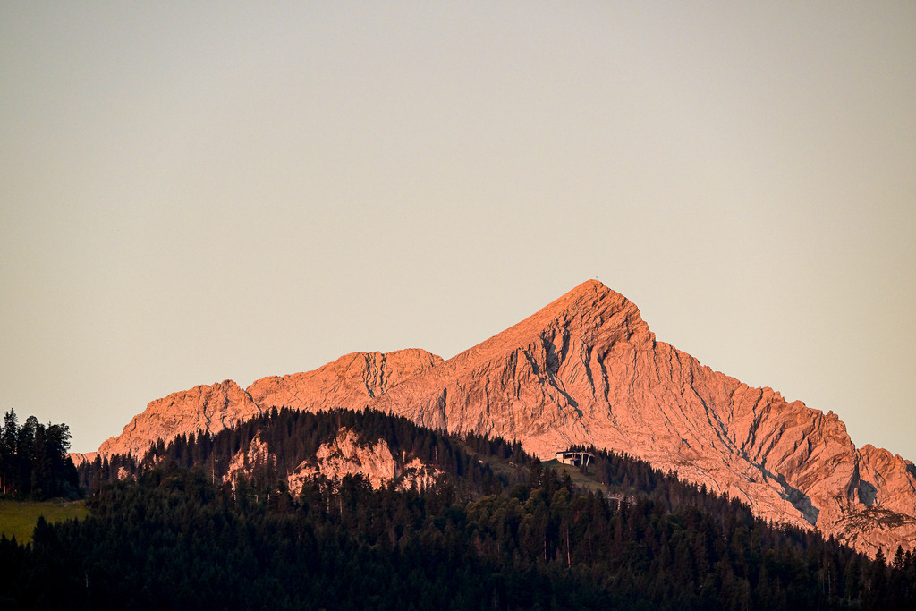 Alpenglühen: Wenn die Berge Feuer fangen | Erstelle eine kurze, emotionale Bildbeschreibung (rund 500 Zeichen), ohne das Foto zu verändern, mit griffiger Überschrift sowie Hashtags/Schlagwörter (für Fotodatenbank) ohne #, getrennt durch Kommata - Realisiert mit Pictrs.com
