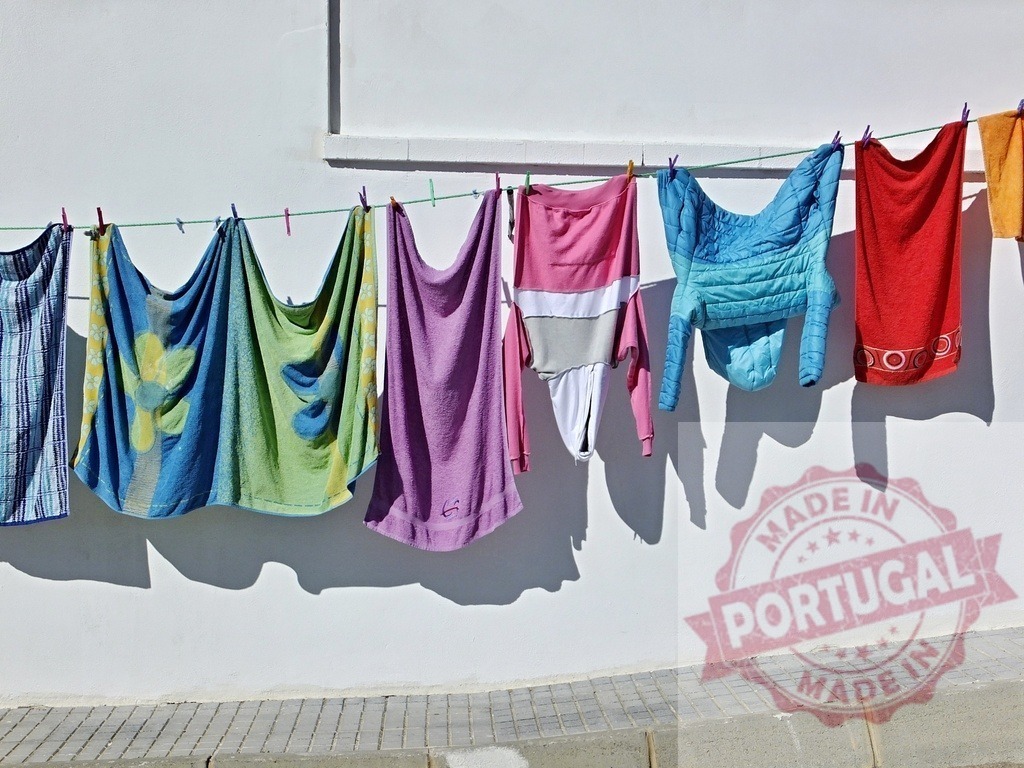 Colorful laundry drying on clothesline in sunlight | Bright clothes and towels hanging on a clothesline against a white wall creating shadows - Realisiert mit Pictrs.com