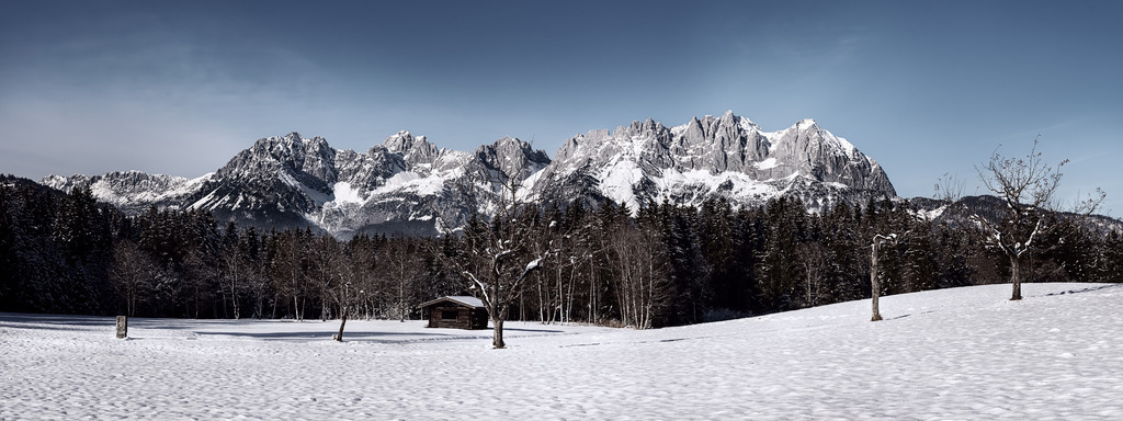 Wilder Kaiser Panorama im Winter in Kitzbühel | Eine schöne Winterlandschaft mit einer Hütte im Vordergrund und dem Wilden Kaiser im Hintergrund. Hochauflösendes Bild für große Drucke geeignet. - Realisiert mit Pictrs.com