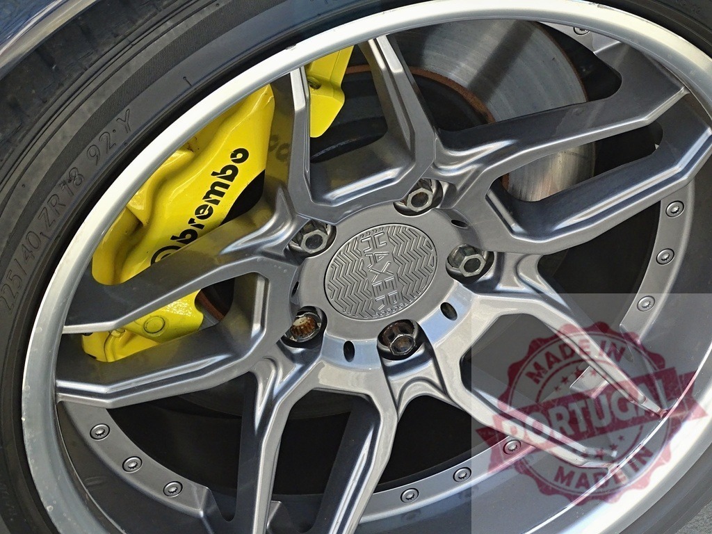 Car wheel showing Haxer alloy rim and yellow Brembo caliper | Car wheel with custom Haxer alloy rim and high-performance yellow Brembo brake caliper - Realisiert mit Pictrs.com