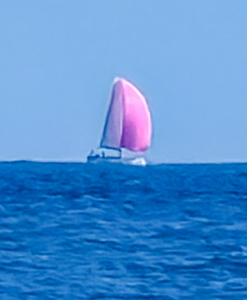 Wandbild Rosa Segelboot auf dem Meer - Maritime Fotokunst | Dieses lichtdurchflutete maritime Wandbild fängt das pure Gefühl von Freiheit und sommerlicher Leichtigkeit ein. Ein elegantes Segelboot mit einem leuchtend rosa-magentafarbenen Segel gleitet majestätisch über das tiefblaue, sanft gewellte Meer. Fotograf Robert Steinke inszeniert das Spiel aus lebendigen Farbkontrasten und unendlicher Weite in gestochen scharfer Premium-Qualität. Ein erfrischender und stilvoller Blickfang, der eine beruhigende, urlaubsähnliche Atmosphäre in moderne Wohnzimmer, Schlafbereiche oder Wellness-Oasen bringt. Perfekt geeignet als großformatiger Kunstdruck auf edlem Alu-Dibond, Leinwand oder unter brillantem Acrylglas für eine faszinierende Farbtiefe und Tiefenwirkung. - Realisiert mit Pictrs.com
