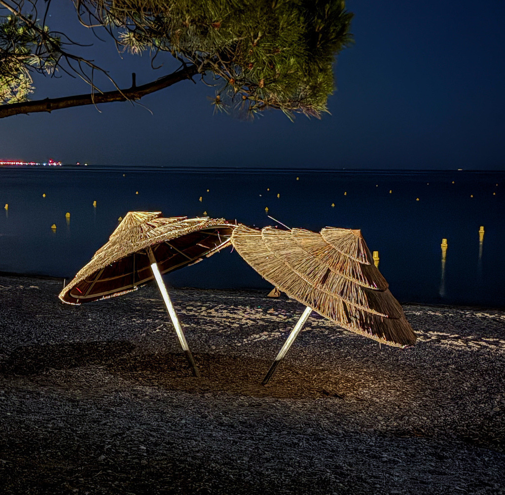 Mitternachtsleuchten – Edle Fotokunst Côte d’Azur | Ein exklusives Stück Urlaubsgefühl für deine Wände. Diese stimmungsvolle Nachtfotografie fängt die beleuchteten Strandschirme an der nächtlichen Küste von Villeneuve-Loubet an der französischen Riviera ein. Das warme, goldene Licht im harmonischen Kontrast zum tiefblauen Mittelmeer und dem dunklen Strand bringt eine elegante, beruhigende und maritime Atmosphäre in moderne Wohnräume, Schlafzimmer oder Ferienhäuser. Empfohlen als Großformat unter Acrylglas für eine beeindruckende Farbbrillanz und Tiefenwirkung. - Realisiert mit Pictrs.com
