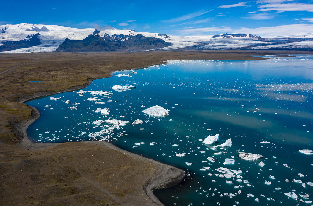 island-DJI_0524 | Jökulsárlón ist eine Gletscherlagune, die an den Nationalpark Vatnajökull im Südosten Islands angrenzt. Im Wasser schwimmen unzählige Eisberge des Vatnajökull-Gletschers, dessen Ausläufer im Hintergrund zu sehen ist. - Realisiert mit Pictrs.com