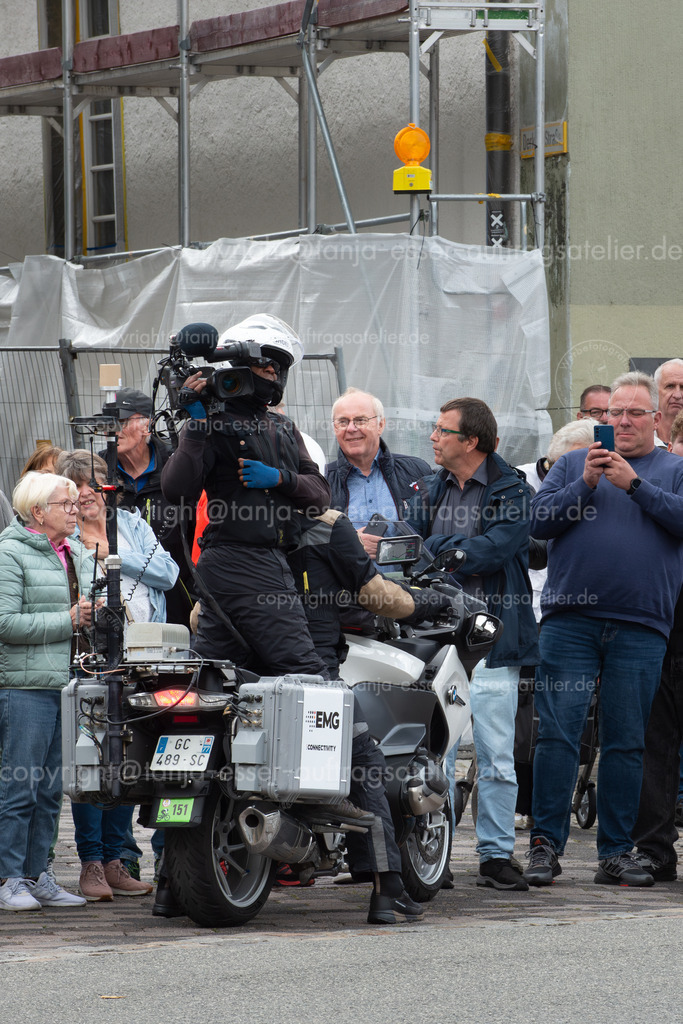 Motorrad Kamermann Deutschlandtour | Brilon, Nordrhein-Westfalen, Deutschland – 23. August 2025: Die Lidl Deutschlandtour erreicht die Stadt. Das professionelle Radrennen wird live im Fernsehen übertragen. Ein Motorrad chauffiert einen Kameramann. 