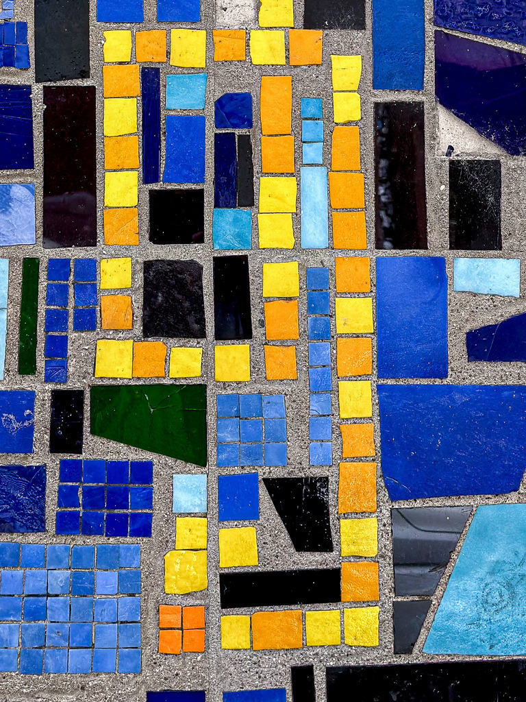 Farbenfrohes Fliesen Mosaik | Geometrische Architektur Fotokunst | Urbane Lebensfreude und präzise Geometrie. Diese detailreiche Architektur-Fotografie fängt ein lebendiges Mosaik-Muster aus blauen, gelben und roten Keramikfliesen in einer ausdrucksstarken Komposition ein. Als großformatiges Wandbild (besonders leuchtend und brillant als Gallery-Print unter Acrylglas) bringt dieses moderne Kunstwerk fröhliche Akzente und mediterranes Flair in deine Küche, den Flur oder das Wohnzimmer. - Realisiert mit Pictrs.com