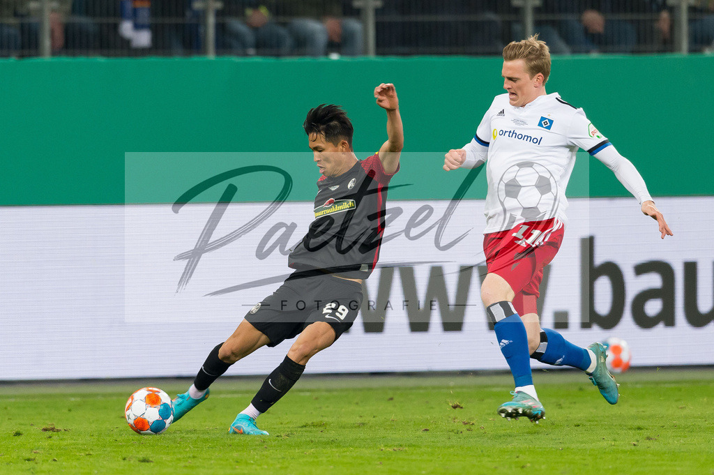 HSVSCF20220419_391 | Fussball, Herren: Woo-yeong Jeong (SC Freiburg) und Mikkel Kaufmann (Hamburger SV) im Zweikampf beim DFB-Pokal-Halbfinalspiel zwischen Hamburger SV und SC Freiburg im Volksparkstadion am 19.04.2022 in Hamburg, Deutschland.DFB / DFL REGULATIONS PROHIBIT ANY USE OF PHOTOGRAPHS AS IMAGE SEQUENCES AND/OR QUASI-VIDEO. - Realisiert mit Pictrs.com