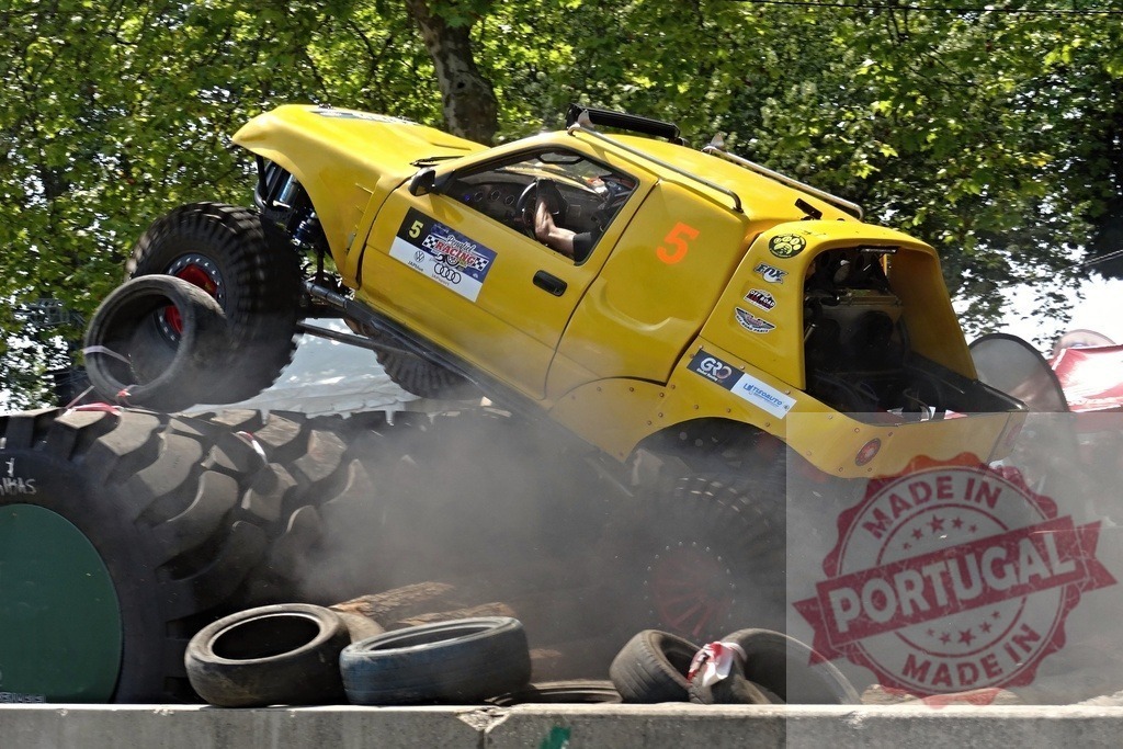 Yellow off-road vehicle climbing over tires during a race | Powerful yellow buggy climbing over tires during an off-road competition, generating dust and excitement - Realisiert mit Pictrs.com
