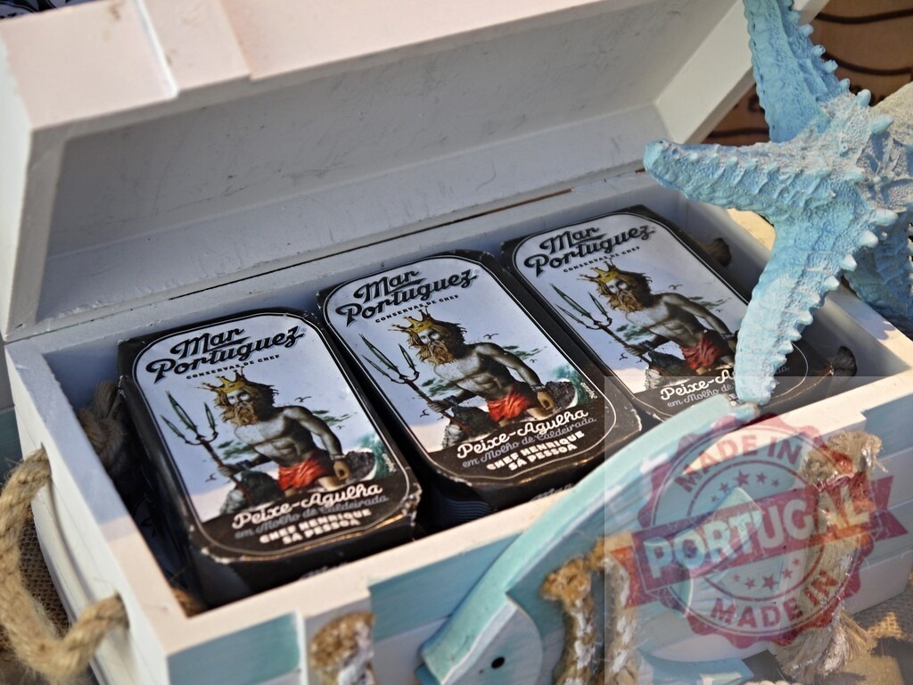 Portuguese canned fish in decorative wooden chest | Mar Portuguez canned fish tins inside a white wooden chest with nautical decor - Realized with Pictrs.com