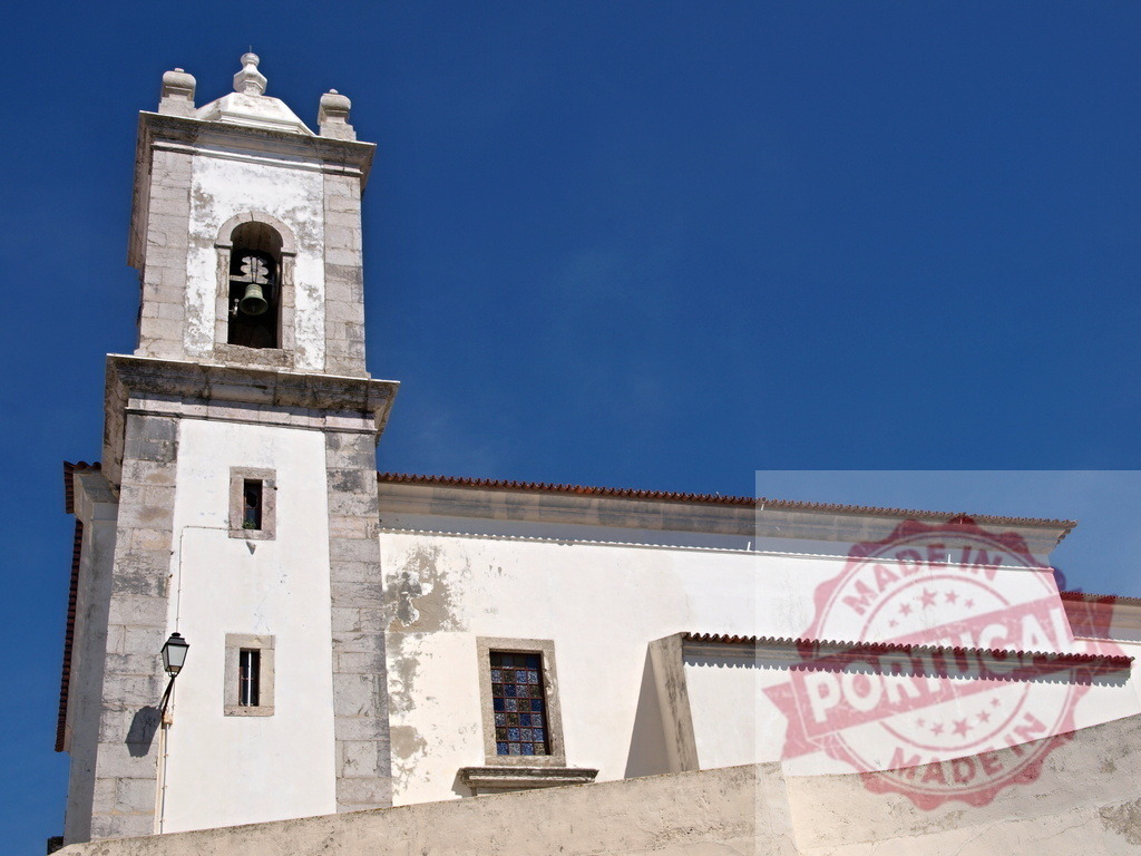 White portuguese church bell tower under blue sky | Historic church architecture featuring a bell tower and white facade against a sunny blue sky - Realisiert mit Pictrs.com