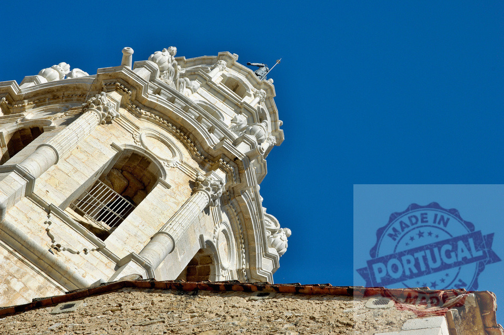 Ornate baroque bell tower against a clear blue sky. Provincia Castellon - Spain | Ornate baroque church bell tower featuring decorative stone details against a clear blue sky - Realized with Pictrs.com