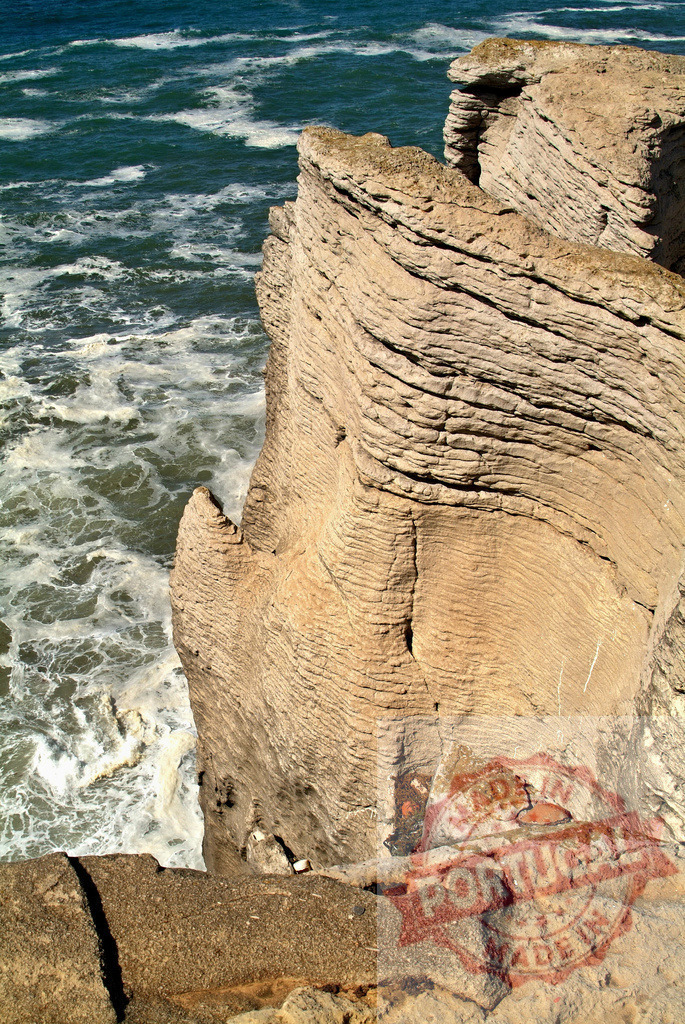 Ocean waves eroding layered limestone rock formations. Centro Portugal | Rugged coastal cliffs featuring distinct stratified rock and crashing ocean water - Realisiert mit Pictrs.com