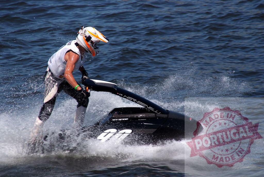 Pilot riding jet ski during competition on water splashes | Professional pilot competing in a jet ski race, creating splashes of water - Realisiert mit Pictrs.com