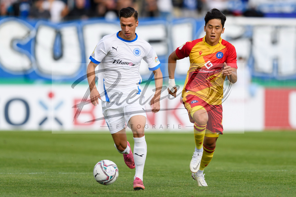 LOTKSC20210809_077 | Fussball, Herren: Tyson Richter (Sportfreunde Lotte) und Kyoung-rok Choi (Karlsruher SC) im Zweikampf beim Spiel der 1. Runde im DFB-Pokal zwischen SF Lotte und Karlsruher SC im Stadion am Lotter Kreuz am 09.08.2021 in Lotte, Deutschland.DFB / DFL REGULATIONS PROHIBIT ANY USE OF PHOTOGRAPHS AS IMAGE SEQUENCES AND/OR QUASI-VIDEO. - Realisiert mit Pictrs.com